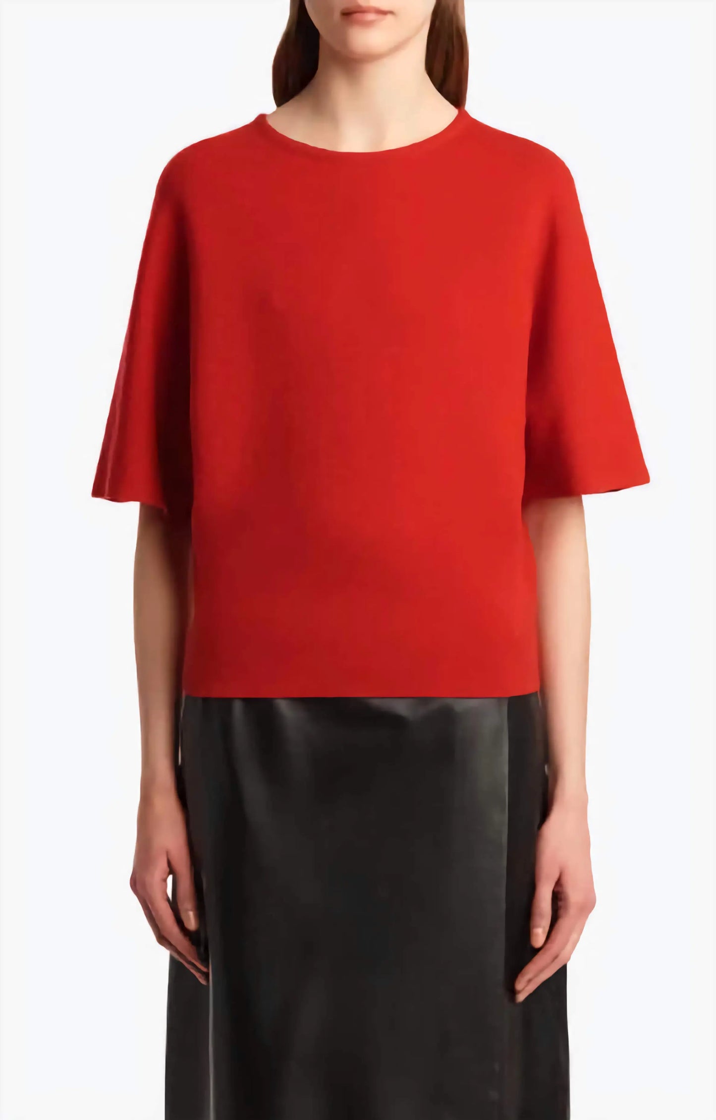 Person wearing a red top and black pants on a white background