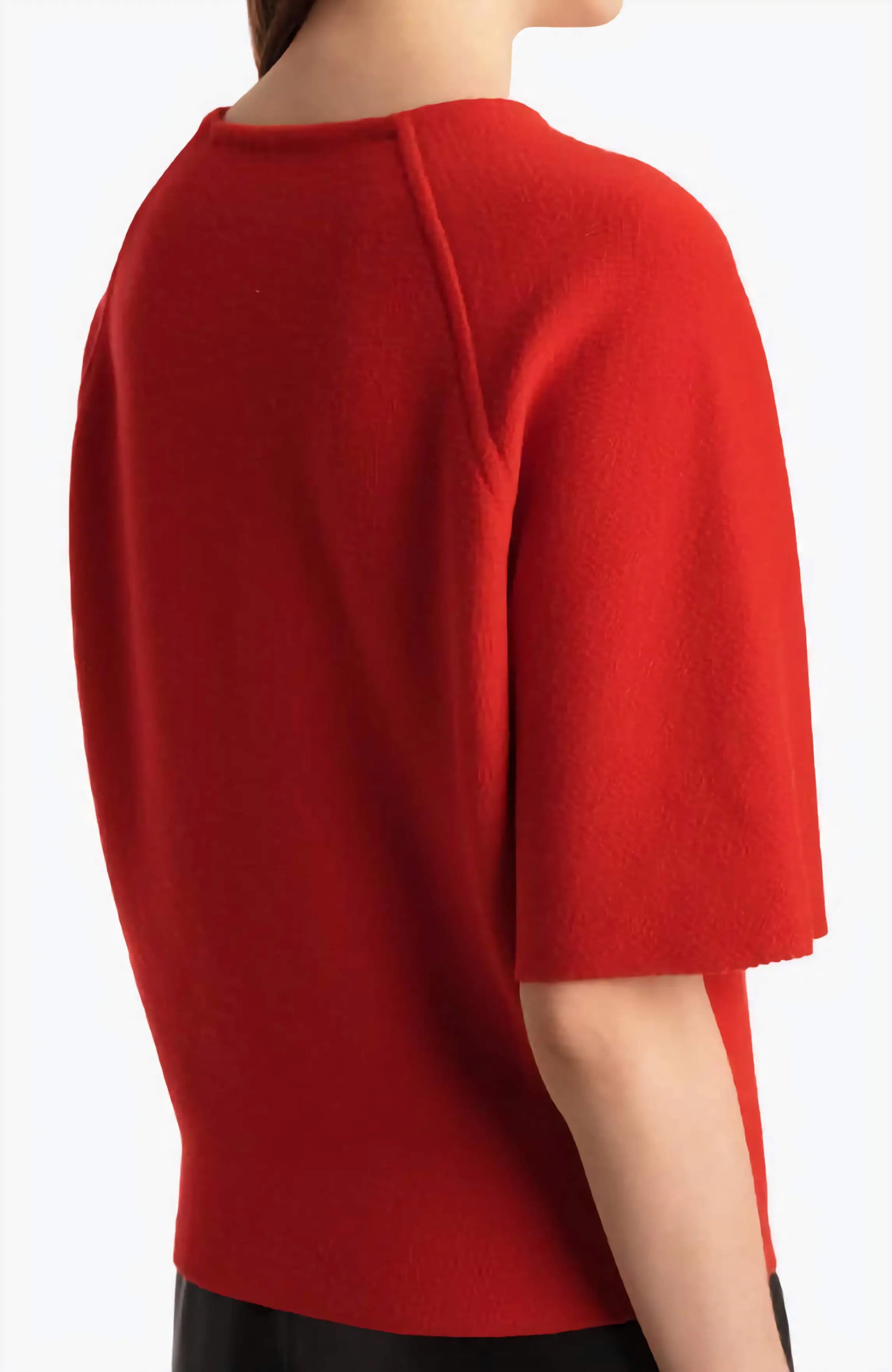 Red top worn by a person on a white background