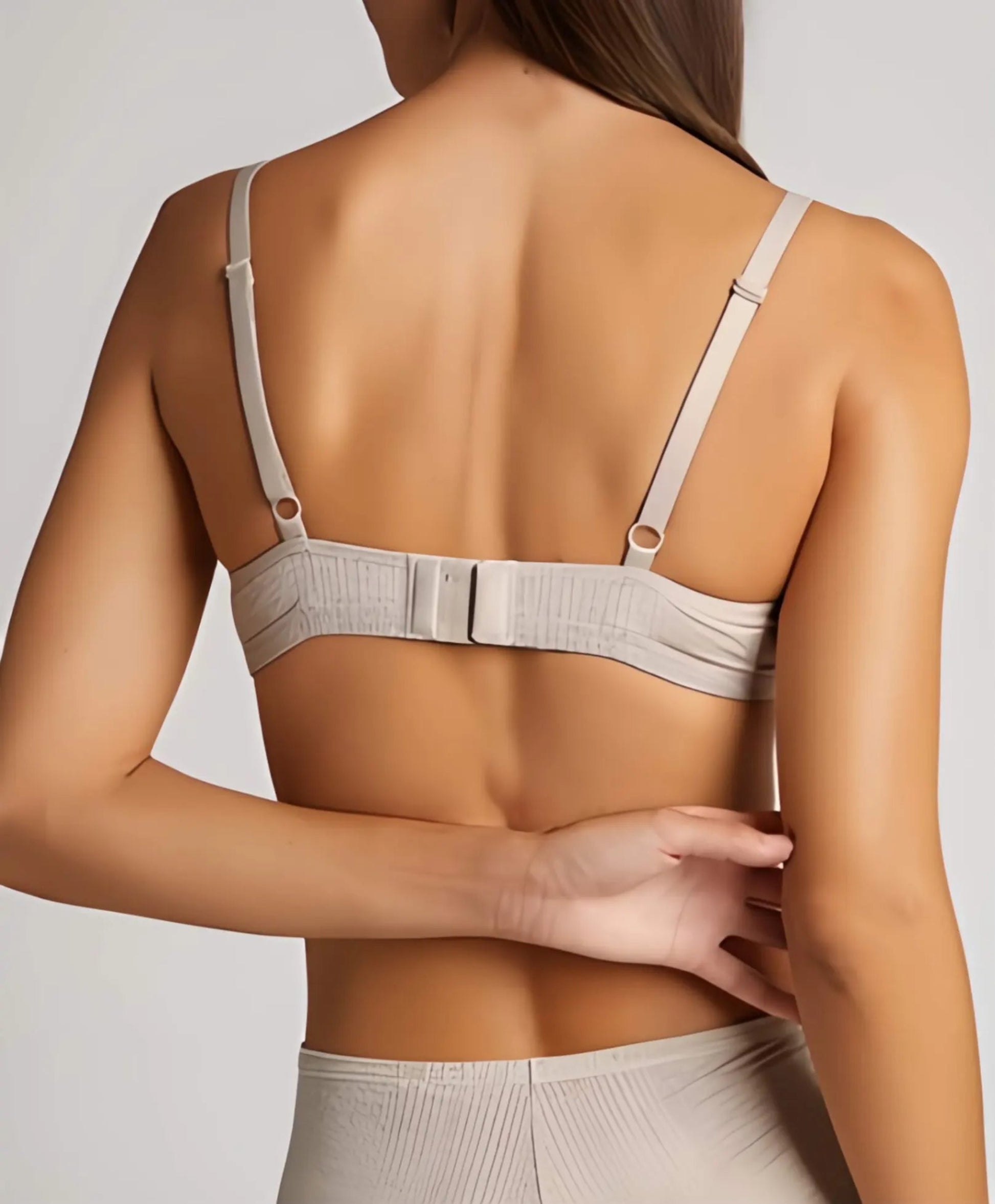 Beige bra worn by a person on a plain background